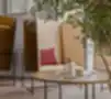 Boxy kolekcija – akustiniai poilsio foteliai su medinėmis sienelėmis šiuolaikiškame biuro interjere su apvaliu kavos staliuku ir dekoru.