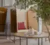 Boxy kolekcija – akustiniai poilsio foteliai su medinėmis sienelėmis šiuolaikiškame biuro interjere su apvaliu kavos staliuku ir dekoru.