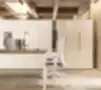 Aukštos baltos biuro spintos su paslėptomis rankenomis, moderniame interjere šalia darbo stalų su kompiuteriais ir ergonominėmis kėdėmis.