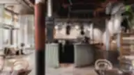 Modernus ir elegantiškas Brasserie RIVOLI interjeras su centriniu baru, aukštomis lubomis, apvaliais šviestuvais ir natūralios šviesos pripildyta erdve.