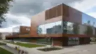 Modernus Rezeknės technologijų akademijos pastatas su stikliniais fasadais ir corten plieno apdaila.