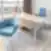 Modernus Nordclinic gydytojo kabinetas Kaune su mėlynomis kėdėmis, lenktu mediniu stalu ir miesto panorama pro langą.
