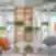 SHED Co-living Vilnius poilsio erdvė su moderniomis kėdėmis, apvaliais staliukais, medinėmis lentynomis ir kambariniais augalais.