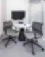 Mažas modernus susitikimų kambarys su apvaliu stalu, dviem ergonomiškomis tinklinėmis kėdėmis ir sieniniu ekranu – AmerisourceBergen - World Courier Lietuva
