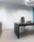 Juodas New Crush vadovo stalas su ergonomine kėde, baltomis sienomis, mėlynu akustiniu lubų bėgiu, rožiniu pliušiniu flamingu ant spintelės ir neono užrašu „We make things happen“