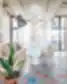 Jauki SHED Co-living Vilnius sėdėjimo zona su popieriniais žibintais, apvaliu stalu, šiuolaikiškomis kėdėmis ir kambariniais augalais.