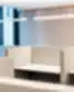 Šviesi biuro zona, kurioje įrengti atskiri darbo pod’ai su šviesiai pilkais, audiniu dengtais pertvaromis aplink baltus stalus. Iš viršaus dėlionės apšviečiamos trimis minimalistiniais linijiniais pakabinamais šviestuvais, o kairėje esantis didelis langas pripildo patalpą natūralia šviesa. Užpildai ant galinės sienos – smėlio spalvos akustinės plokštės.