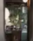Žalias medis interjere, matomas pro veidrodžio rėmą Brasserie RIVOLI restorane.