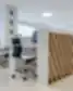 Modernios darbo vietos Clinic DPC dantų priežiūros centre su kompiuteriais, ergonomiškomis kėdėmis ir dokumentų lentyna.