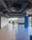 Šiuolaikiška Socialinių mokslų kolegijos bendro naudojimo erdvė su stiklinėmis sienomis, moderniu apšvietimu ir darbo zonomis.