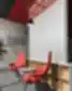 Emergn biuro poilsio zona su raudonomis kėdėmis, šūkiu ant sienos ir moderniu apšvietimu