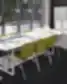 Modernus biuro interjeras su darbo stalu, konferenciniu stalu ir žaliomis kėdėmis prie lango Rezeknės technologijų akademijoje.