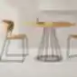 Šviesios medienos ARC kėdės ir apvalus medinis stalas.
