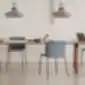Dvi mėlynos Aryn Max kėdės prie medinio stalo moderniame interjere