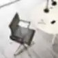 juoda luma kėdė prie balto stalo šviesiame biure