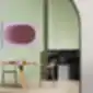 NEMEA kėdė iš PEDRALI moderniame interjere su žalia siena ir rožiniu paveikslu.