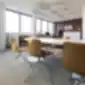 ARPER CATIFA 46 konferencinė kėdė su rudu apmušalu biuro erdvėje.