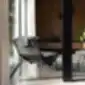 Ronin krėslas iš NOTI šalia apvalaus lango.